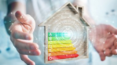 Energieeffizienz im Fokus: Ein Haus mit Bewertungsskala Zwei Hände die ein Energieeffizienzklasse mit einem Haus umrandet halten