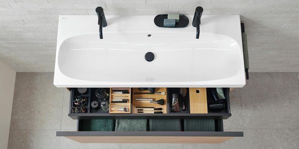 Ein elegantes Badezimmer mit einer weißen Badewanne und einem modernen Waschbecken, das stilvoll dekoriert ist.