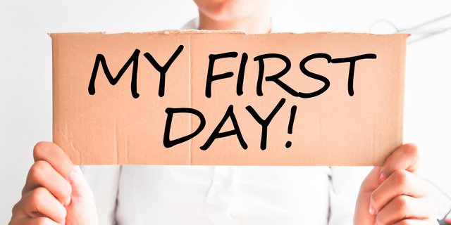 Mein erster Arbeitstag: Aufregung und Vorfreude Zwei Hände die ein stück Pappe hoch halten auf dem My First Day! steht