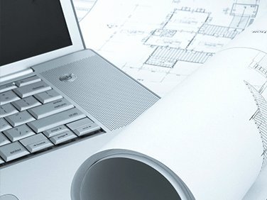Architektonische Pläne und Laptop auf einem Tisch Bauzeichnungen und ein Laptop