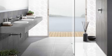 Ein modernes Badezimmer mit einem eleganten Waschbecken aus Beton und Blick auf einen ruhigen See durch große Fenster.